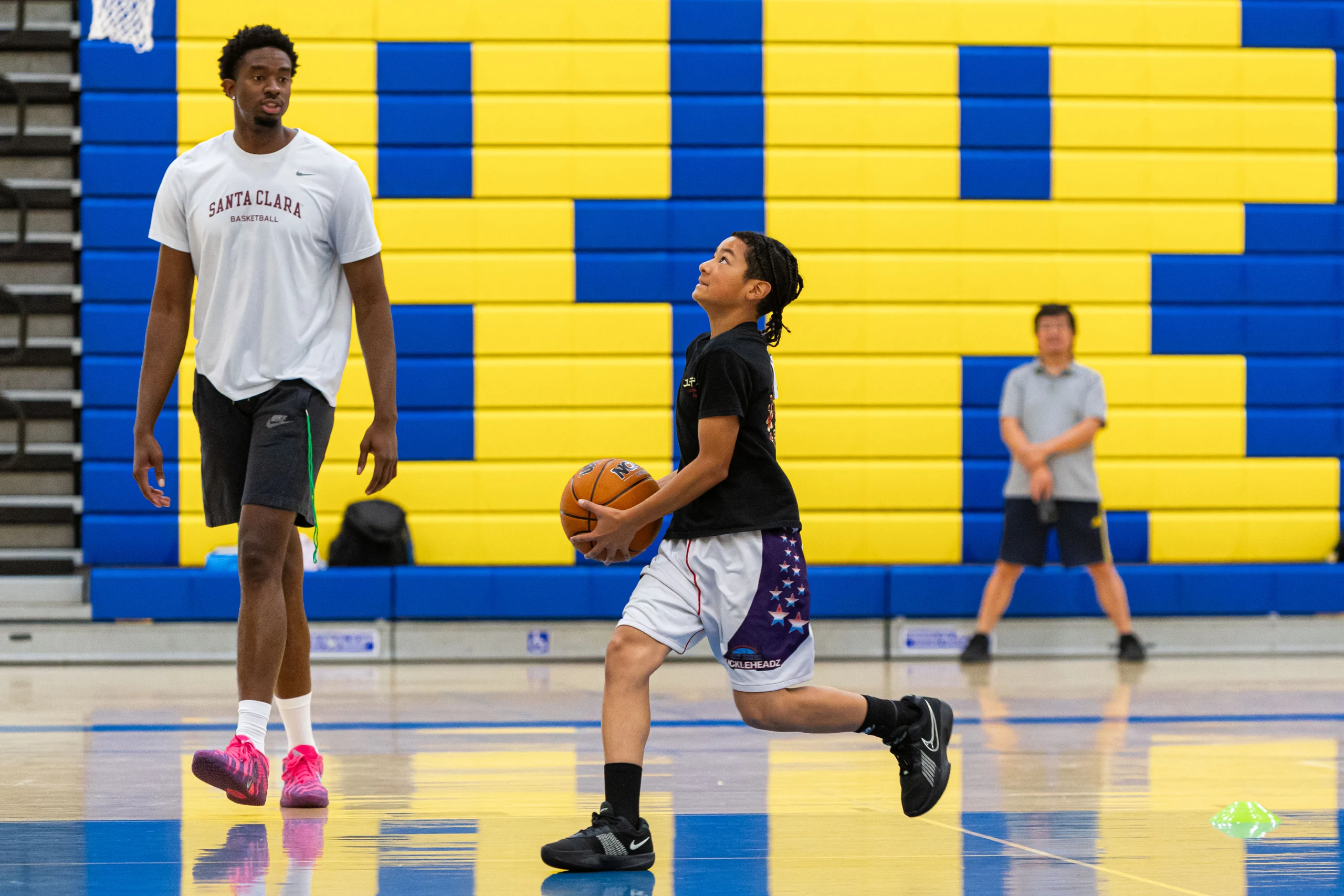 Campers and a Santa Clara University player on the court