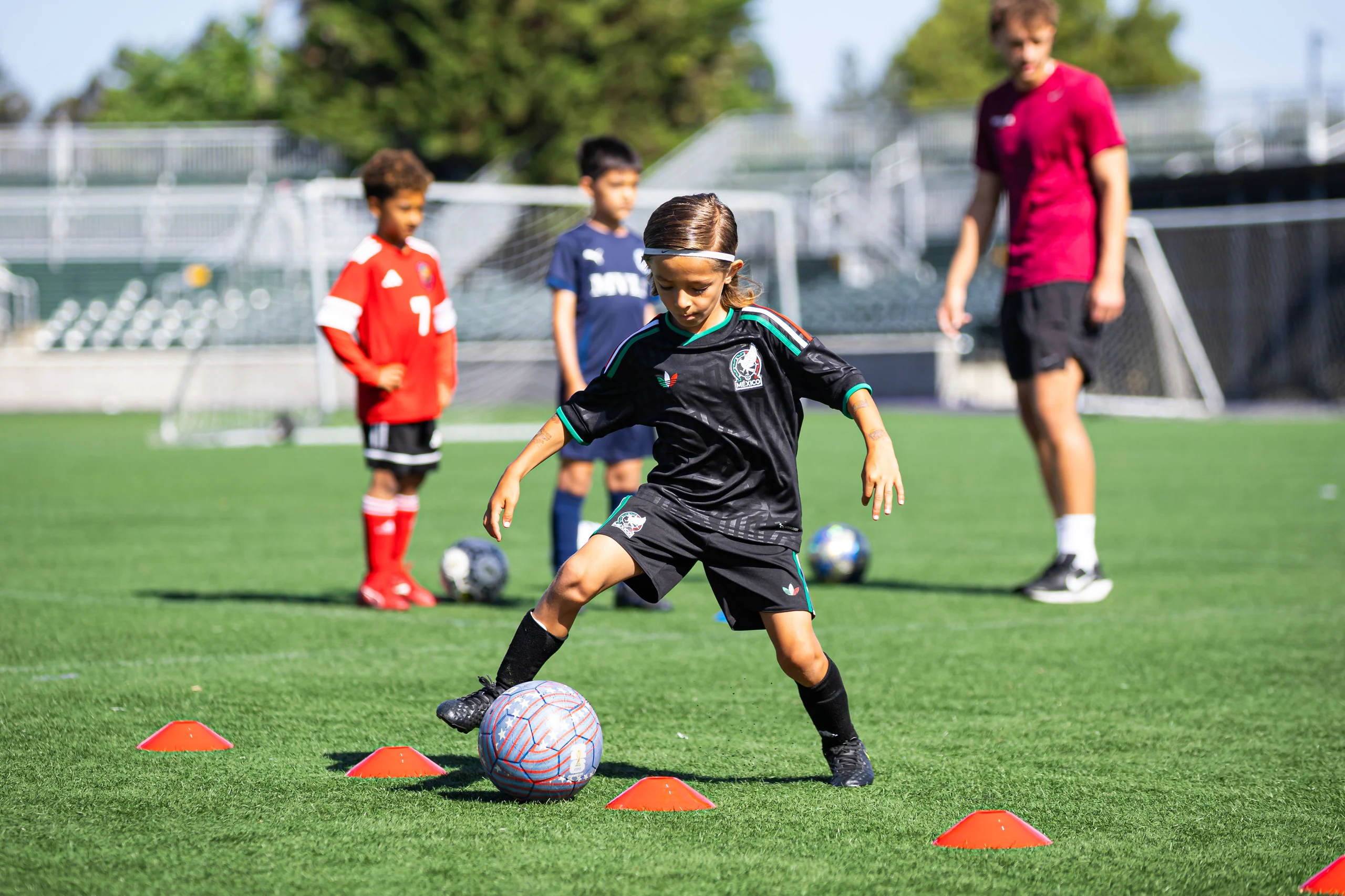 A Santa Clara University player coaches young campers at the 2026 men's soccer clinic