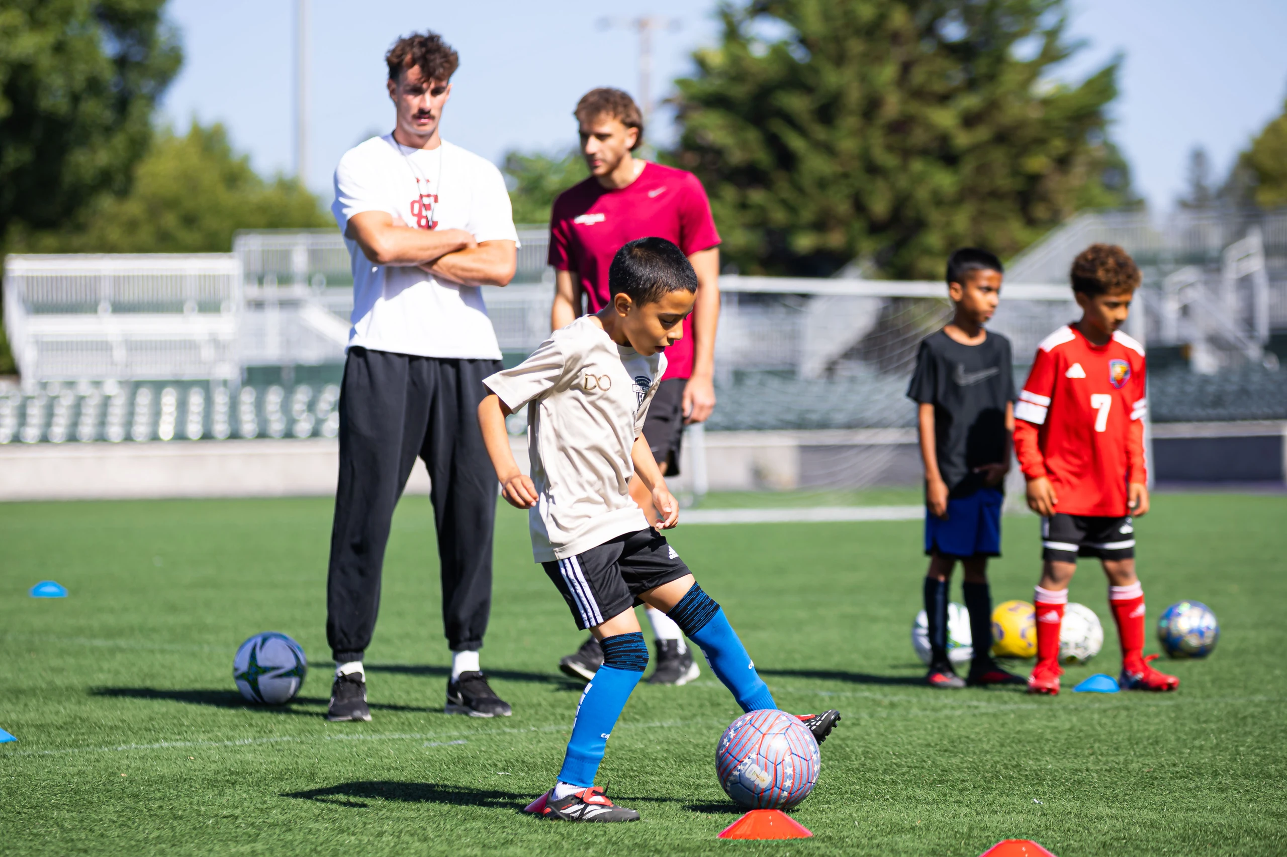 Campers training with a Santa Clara University player at the men's soccer clinic