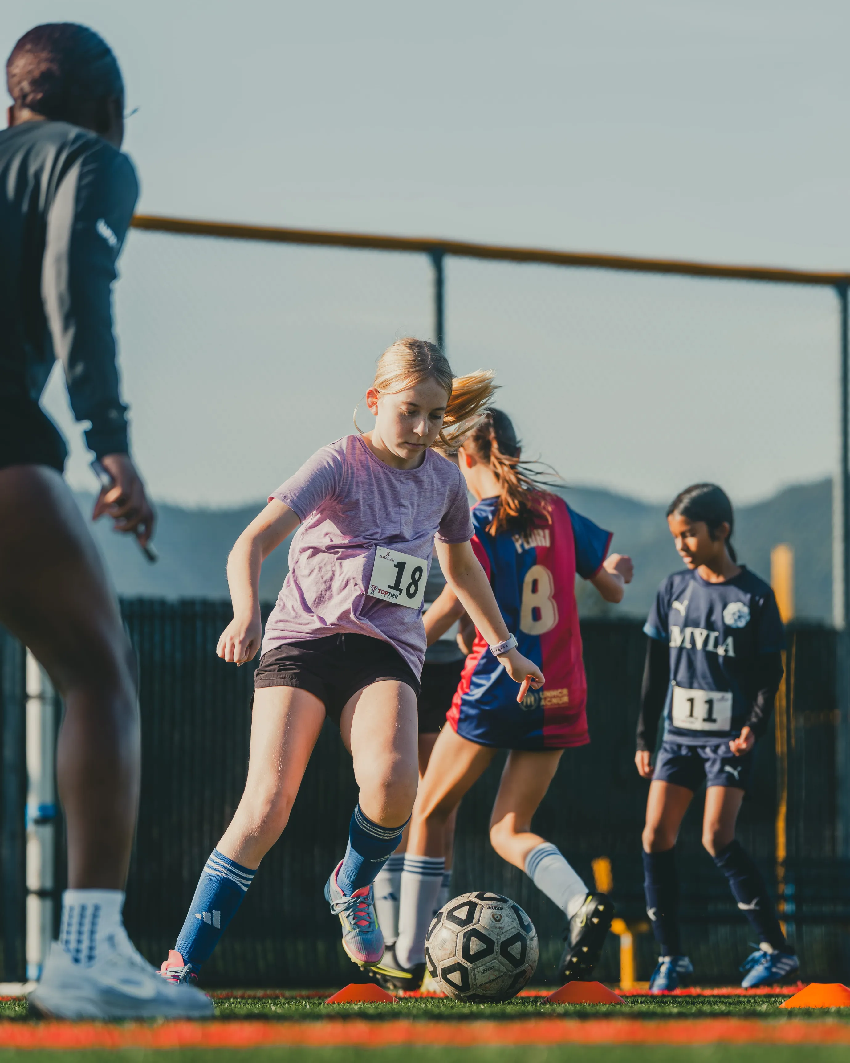 A young player works through a ball-striking drill at a Santa Clara women's soccer camp