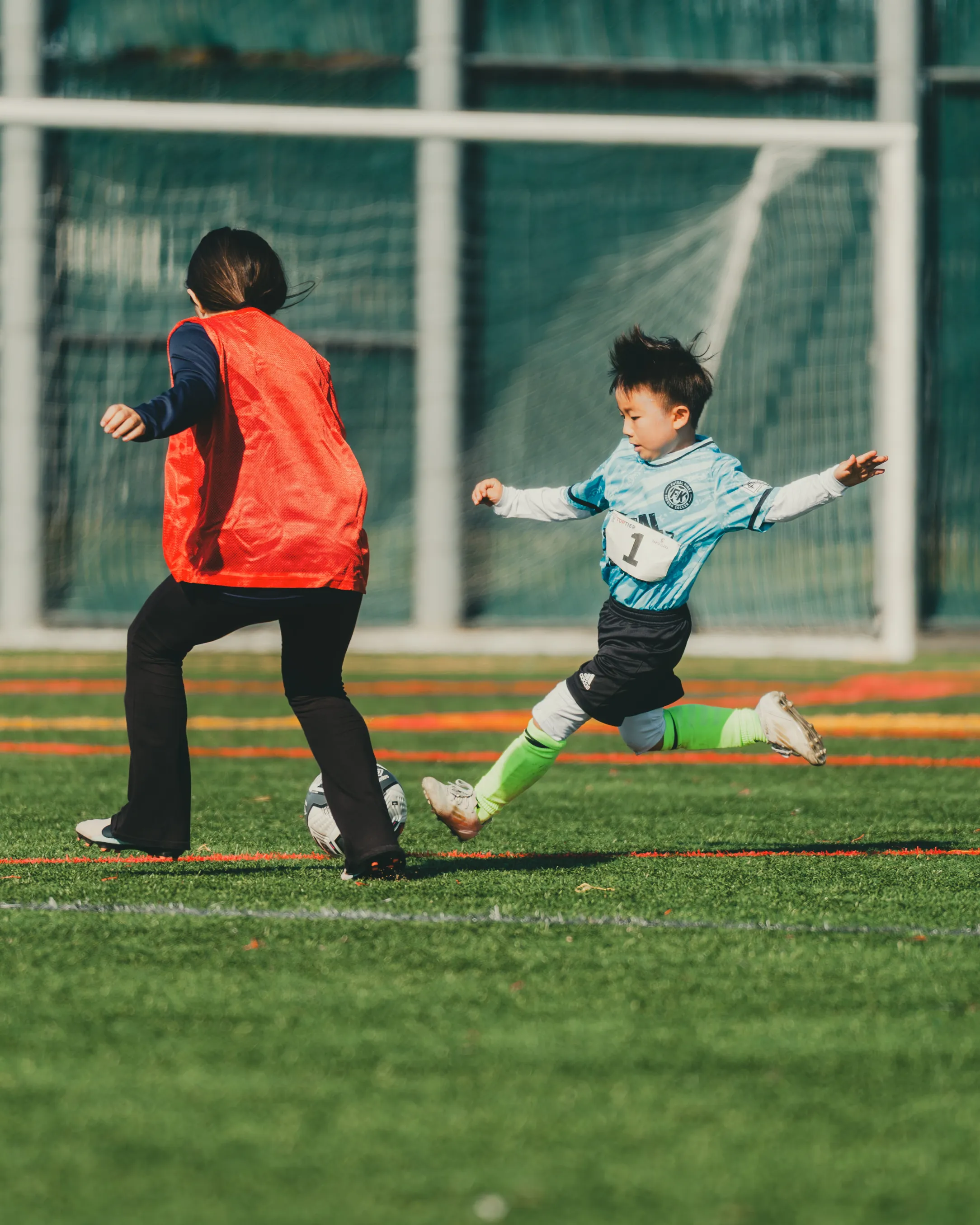 A young camper dribbling through a drill